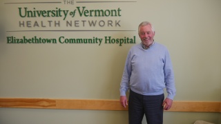 Thomas Dwyer poses in front of a sign.
