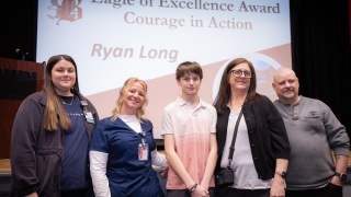 Kaylee Miller, RN, and Linda Dumbuya, RN, both emergency department nurses at Champlain Valley Physicians Hospital, with Ryan Long, 14, and his grandparents, Michelle and Charlie Hunt during a ceremony at Beekmantown Middle School.