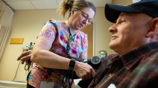 A primary care provider at Middlebury Primary Care at Porter Medical Center checks a patient's blood pressure.