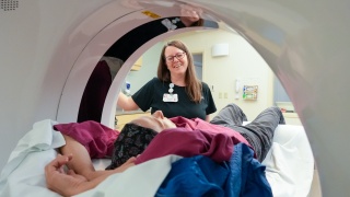 A medical professional helps a patient in a scan.