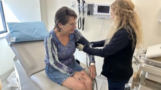 A medical provider checks a patients' blood pressure.