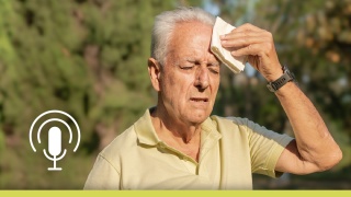 Older man patting sweat on his forehead with a hankerchief.