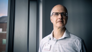 Portrait of Steven Ades, MD standing next to a window.