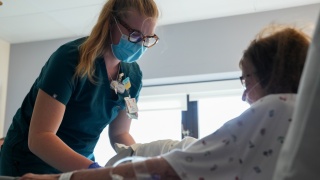 Izzy Paquette therapy aide helping a patient in their exam room.