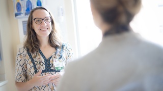 Dr. Fenton speaks with patient in exam room.