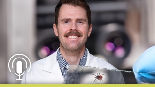Portrait of Peter Hyson, MD overlaid with a tick on a slide in the bottom right and a microphone icon in the lower left.