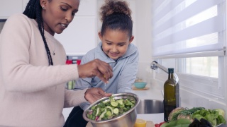 an adult and child cooking together 