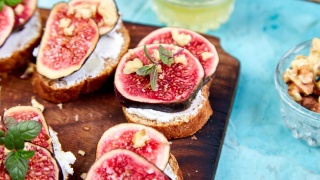 Walnut fig goat cheese bread appetizer sits on a cutting board.