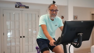 Cardiology patient Buddy Singh rides exercise bike at home