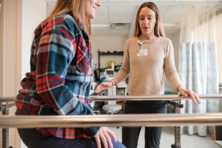 A nurse helps a patient with rehabilitation therapy. 