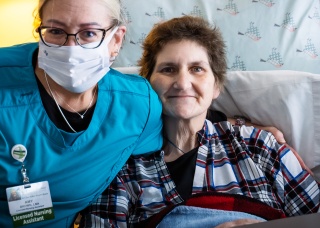 A Home Health and Hospice nurse smiles with a resident of the McClure Miller Respite House.