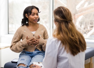 An adolescent patient speaks with medical provider.