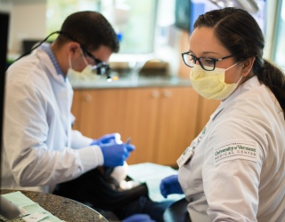 UVM Medical Center dental providers working on a reclined patient. 