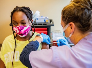 A young adolescent patient receives a vaccination. 