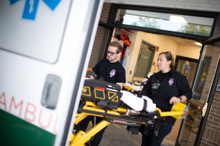 Two paramedics transport patient from an ambulance.