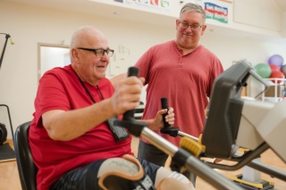 A physical therapist helps a patient exericse.