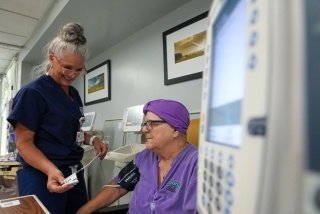 A nurse helps a patient with an infusion.