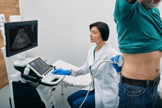 A medical provider conducts an ultrasound of a patient's kidney.