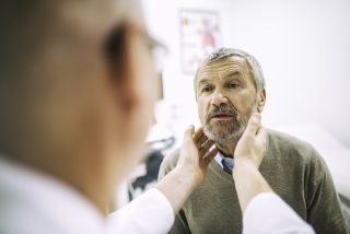 A medical provider checks a patient's neck.