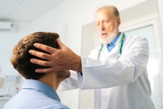 A medical provider checks a patient's head.