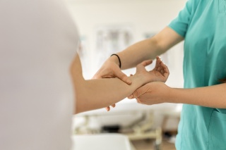A medical provider checks a patient's arm.