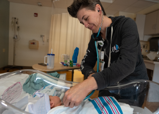 A medical provider checks a newborn baby in the birthing center.