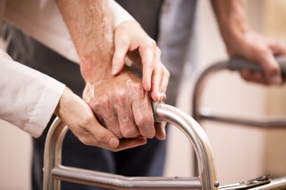 Close-up photo of an adult patient using a walker.