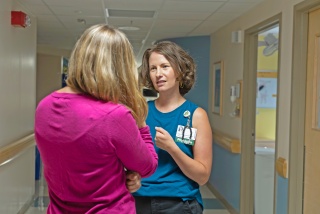 Pediatric palliative care provider speaks with a patient in the hospital.