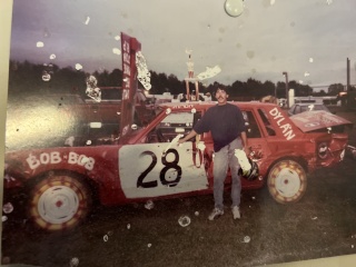 In an undated family photo, Shaun McGuire poses with his demolition derby car. 