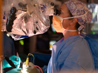 Katrina Ducis, MD, performs brain surgery using microscope.
