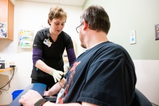 A medical provider draws blood from a patient.