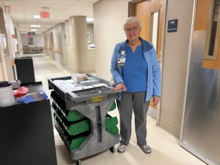 Kathy Durkin stands with the Forget Me Not Cart of personal care items at Alice Hyde Medical Center.
