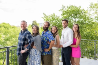 Group photo of the six Emergency Medicine 2026 alums standing outdoors on a balcony.