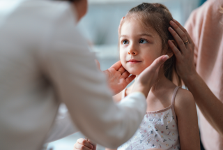 A doctor checks a pediatric patient.