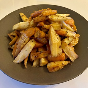 A mix of coriander glazed carrots rests on a plate. 