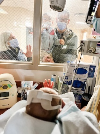 Fitzhugh family looking in windows of UVM Children's Hospital NICU.