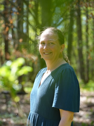 Portrait of Tawnya Kiernan outside in the trees.