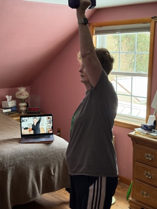 Mary Lodell exercises with hand weights at home.