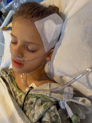 9-year-old Eliza Andrews recovers in her hospital bed after brain surgery.