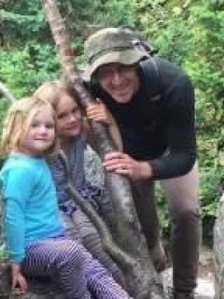 Ryan Walsh, MD outside by tree with his two daughters