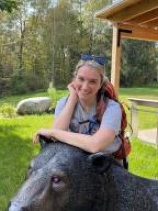 Joanna Pierce, MD leaning on statue of a bear
