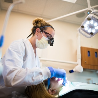 Dental specialist works on patient teeth.