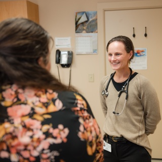 A primary care provider smiles and speaks to patient at Porter Medical Center.