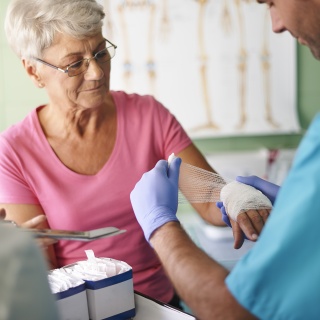 A doctor wraps the hand of a patient.