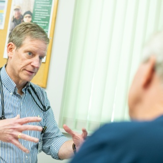 Geriatric medicine specialist speaks with patient.