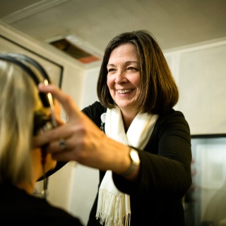 University of Vermont Medical Center Audiology provider adjusts a patients head set.