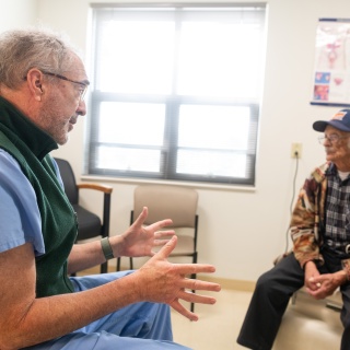 A Central Vermont Medical Center Urologist talks with a patient in an exam room.