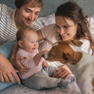 A family of three plays with their dog.