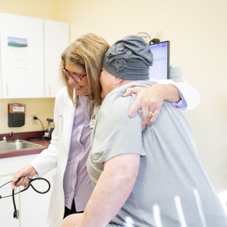 A medical provider hugs a patient.