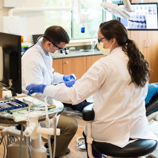Two dentists working on a patient
